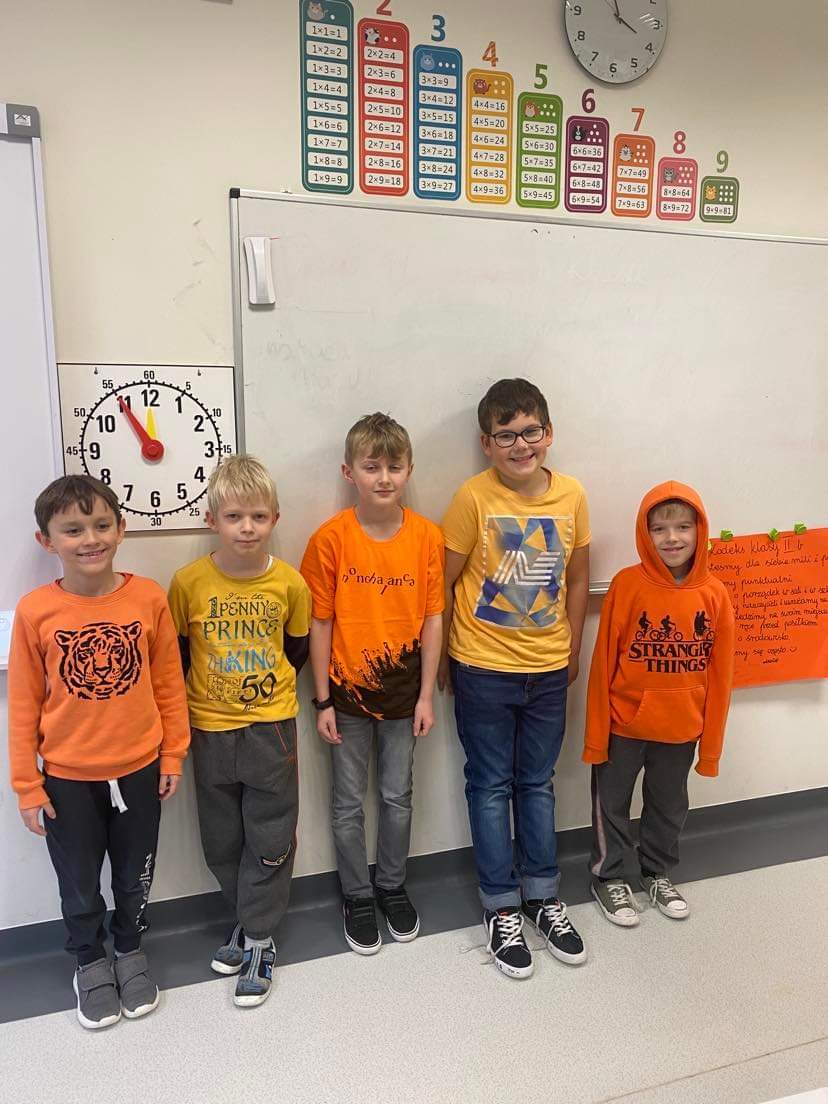 uczniowie w pomarańczowych koszulkach